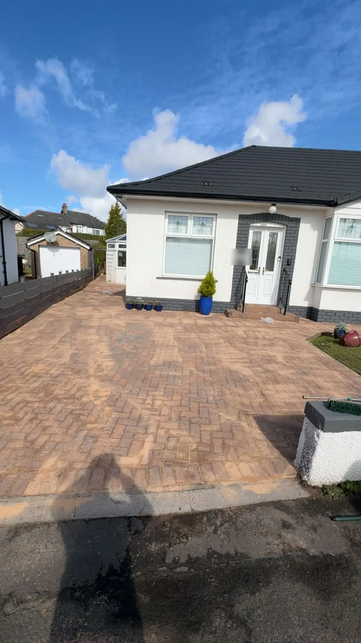 The same block-paved driveway pressure washed clean in front of the bungalow