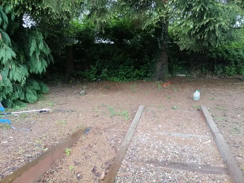Bare ground with sleepers laid either side of a gravel path, before the play area was finished
